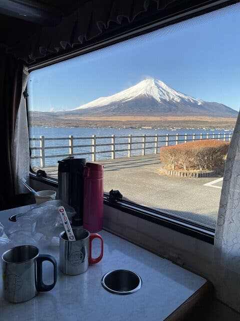 キャンピングカーの窓から見える冬の富士山